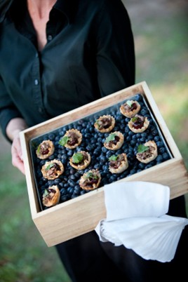 Amuse-bouches raffinés présentés dans un plateau en bois, illustrant les tendances culinaires 2026.