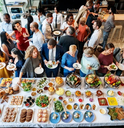 Buffet varié pour un événement d'entreprise avec des invités en discussion.