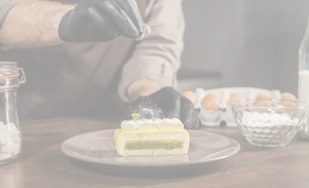 Chef décore un entremet raffiné avec sucre glace, parfait pour pièces cocktails, buffets & évènements privés Gustus Traiteur.