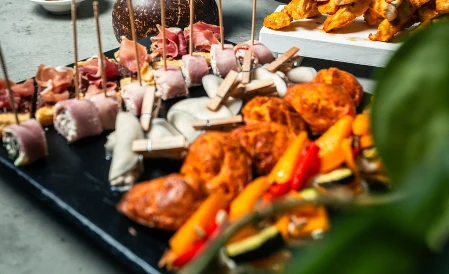Assortiment d'amuse-bouches variés, avec charcuteries, roulés et légumes, idéal pour vos événements privés à Genève.
