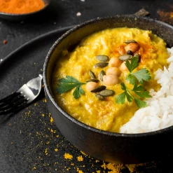 Plateau repas avec curry, riz et garnitures fraîches