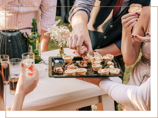 Invités se servant des pièces cocktails variées sur un plateau, parfaites pour des évènements privés avec Gustus Traiteur...